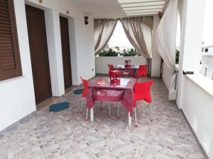 a dining room with red chairs and a table at B&B MareIncantato in Leuca