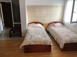 duas camas sentadas uma ao lado da outra num quarto em Family Hotel Panorama em Sarnitsa