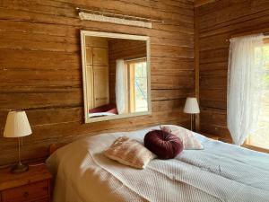 um quarto com uma cama com um espelho na parede em Villa Huvikalliola, LaatuLomat em Sulkava