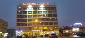 a tall building with cars parked in front of it at Qasayed Hotel فندق قصائد in Salalah