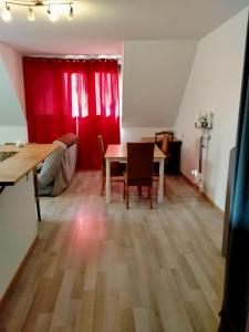 uma sala de estar com uma mesa e uma cortina vermelha em Le Saint Antoine em Saint-Jean-de-Maurienne