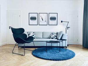 sala de estar con sofá y silla en Pension MONO - Adults Only en Český Krumlov