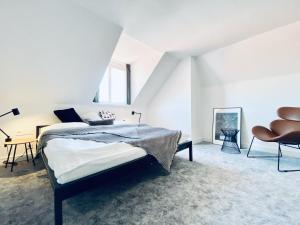 a bedroom with a bed and a chair at Pension MONO - Adults Only in Český Krumlov
