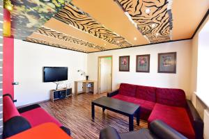 a living room with a red couch and a tv at Travel Apartment in Ventspils