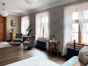 sypialnia z 2 oknami oraz stołem i krzesłami w obiekcie Apartamenti Kuldīgas Pilsdzirnavas w mieście Kuldīga