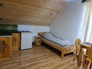 a small room with a bed and a kitchen at Apartamenty w cichej okolicy in Bańska Wyżna