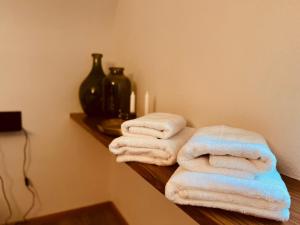 a group of towels sitting on a shelf in a bathroom at BlackNCozy - Großzügiges Designappartement mit Boxspringbetten und Heimkino in Feldberg +16 photos