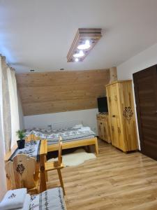 Zimmer mit einem Bett und einem Tisch in der Unterkunft Apartamenty w cichej okolicy in Bańska Wyżna