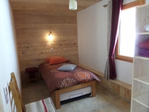 1 dormitorio con 1 cama en una habitación de madera en Gite du Brin d'Herbe, en Pontarlier