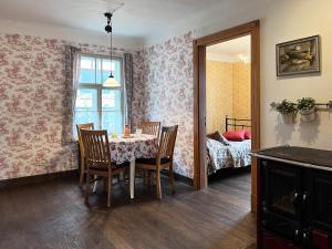 a dining room with a table and chairs and a bedroom at Apartamenti Kuldīgas Pilsdzirnavas in Kuldīga