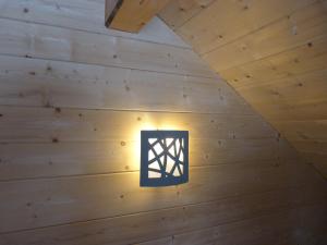 Gite du Brin d'Herbe في بونتارليه: ضوء في غرفة مع ألواح خشبية