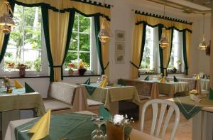 un comedor con mesas, sillas y ventanas en Zenner's Landhotel, en Newel