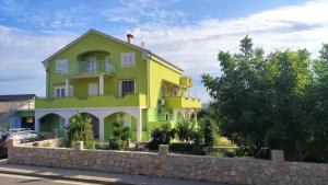 une maison jaune et blanche avec un mur en pierre dans l'établissement Apartmani Juresko Mrljane, à Mrljane