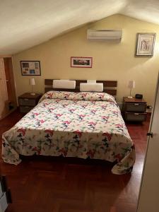 um quarto com uma cama grande e uma colcha floral em Perfetto relax em Arena Metato