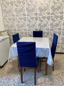 a table with four blue chairs and a white table cloth at Venice -Mestre Rooms in Mestre