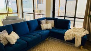 a blue couch in a living room with windows at #7 Highlander, Kings Beach - Beachfront Complex in Caloundra