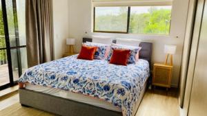 a bedroom with a bed with pillows and a window at #7 Highlander, Kings Beach - Beachfront Complex in Caloundra