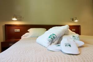 a bed with towels and slippers on top of it at Hotel Manantial in Caldes de Boi