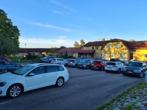 un grupo de autos estacionados en un estacionamiento en Dagsholm Hotell, en Färgelanda