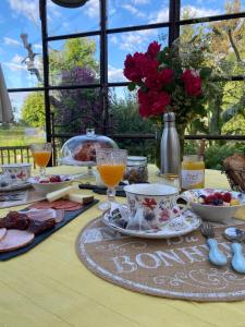 una mesa con comida y bebidas en un mantel amarillo en La Maison du Bonheur en Thiel-sur-Acolin