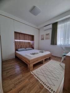 Un dormitorio con una cama con cabecero de madera. en Lovely 1-bedroom rental unit with free parking, en Skopje