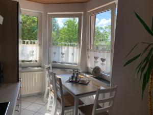 comedor con mesa y 2 ventanas en Haus am Kurpark, en Clausthal-Zellerfeld