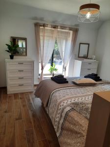 1 dormitorio con cama y ventana en Madelaine Ranch, maison de campagne 10 personnes, en Le Gast