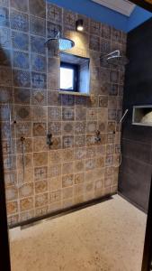 uma casa de banho com um chuveiro e um espelho. em Een vleugje wellness in de Voerstreek - Bed & Brocante Onder de Poort em Voeren