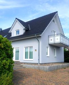 una casa blanca con techo negro en PEMATRA Haus Sonnenschein - FeWo Heimathafen, en Travemünde