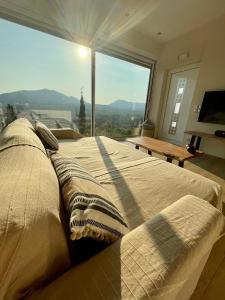 a large bed in a room with a large window at Corfu Gaia View Studio in Episkopianá