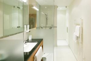 a bathroom with a shower and a sink and a mirror at Hotel Sailer in Innsbruck