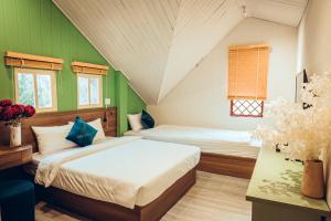 een slaapkamer met 2 bedden en groene muren bij Villa Hoa Da in Da Lat