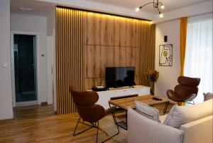 Una sala de estar con televisión, mesa y sillas. en Lovely 1-bedroom rental unit with free parking, en Skopje