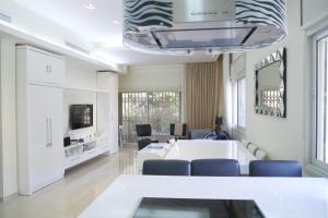 een woonkamer met een witte tafel en stoelen bij Dizengoff - Lovely family apartment 3 rooms. in Tel Aviv