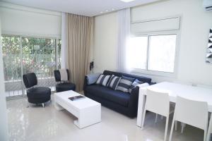 uma sala de estar com um sofá e uma mesa em Dizengoff - Lovely family apartment 3 rooms. em Tel Aviv