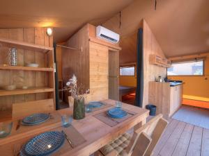 un comedor con una mesa de madera con placas azules en Sea Glamping, en Kotor