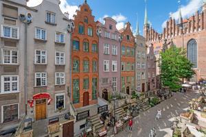 a city street with buildings and people walking on the street at Downtown Apartments Old Town Mariacka in Gdańsk