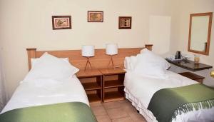 two beds sitting next to each other in a bedroom at Siesta B&B Vryheid in Vryheid