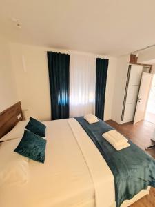- une chambre avec un grand lit blanc et des oreillers bleus dans l'établissement Didova kuća, à Brodarica