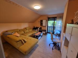 salon z kanapą i stołem w obiekcie Haus Flora - Ferienwohnung Bodensdorf w mieście Bodensdorf +22 zdjęcia