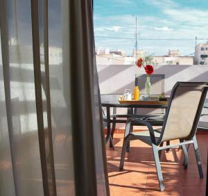 a table and chair on a balcony with a view at La City Estación in Alicante