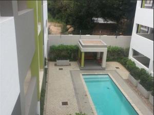 una piscina con una mesa junto a un edificio en Perfect Traveler's apartment, en Johannesburgo