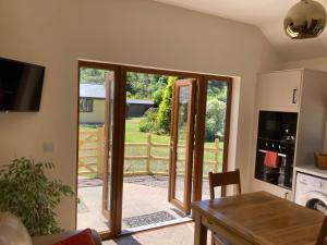 une cuisine avec une porte ouverte sur un jardin dans l'établissement 1 bedroomed Detached holiday retreat Pant, à Oswestry
