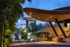 vistas a un edificio con palmeras por la noche en The Sakala Resort Bali All Suites, en Nusa Dua