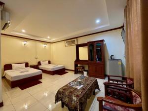 a hotel room with two beds and a table at Sengkeo Hotel in Vientiane