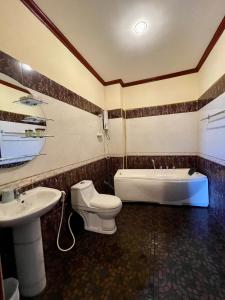 ein Badezimmer mit einer Badewanne, einem WC und einem Waschbecken in der Unterkunft Sengkeo Hotel in Vientiane