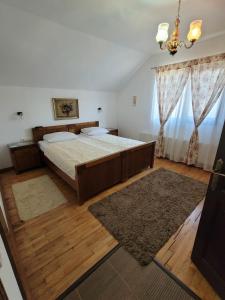 シゲトゥ・マルマツィエイにあるPensiunea Irisのベッドルーム1室(大型ベッド1台、シャンデリア付)