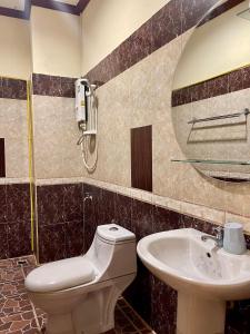 a bathroom with a sink and a toilet and a mirror at Sengkeo Hotel in Vientiane