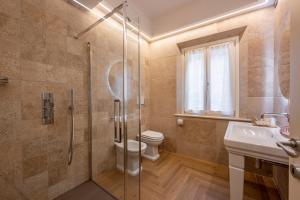 e bagno con doccia, servizi igienici e lavandino. di Palazzo del Mercante a Montepulciano