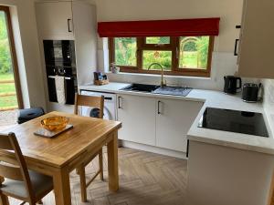 a kitchen with a table and a sink and a table and chairs at 1 bedroomed Detached holiday retreat Pant in Oswestry